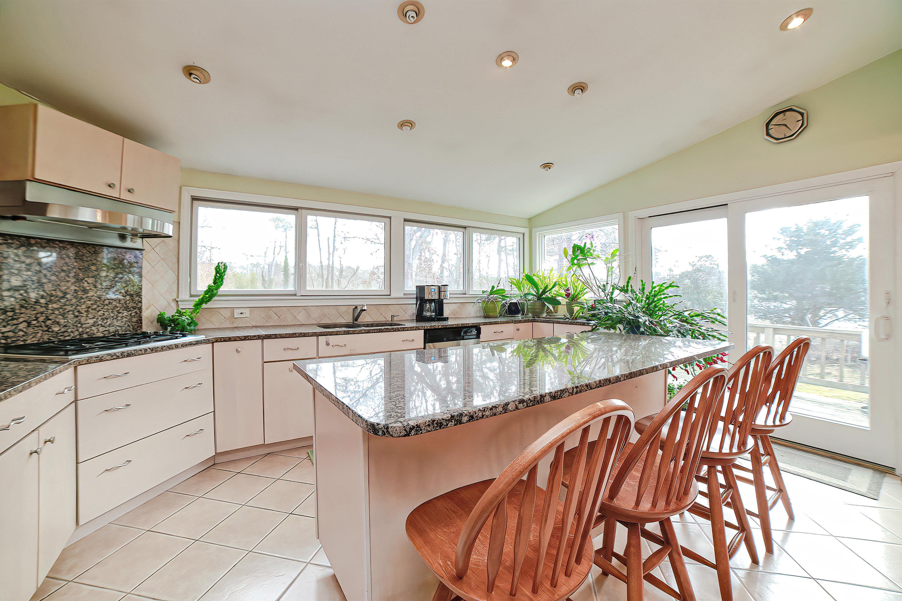 46 Delta Street Hyannis, MA 02601 - Photo 8 of 35 a kitchen with granite countertop a table chairs stove and sink