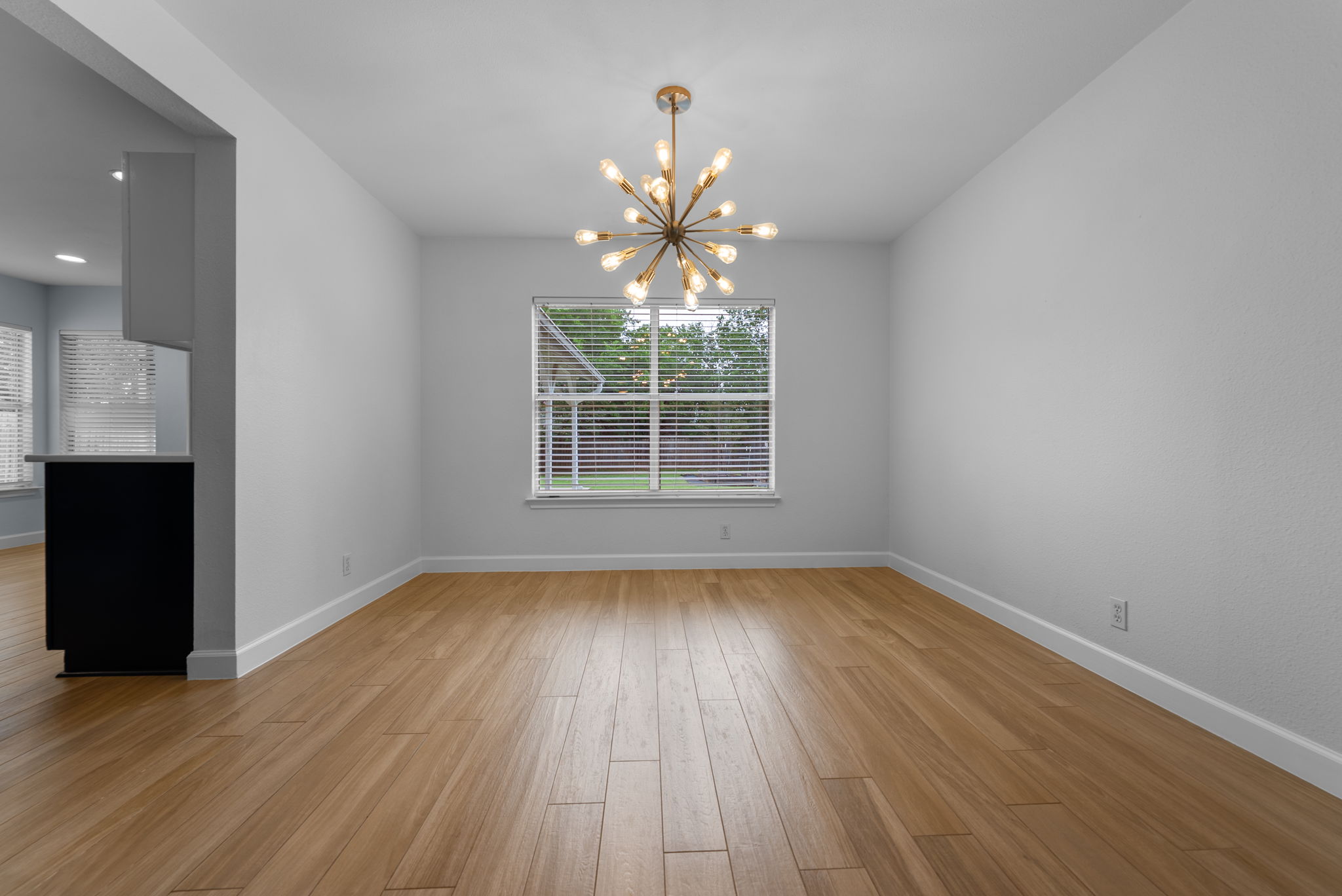 7327 Pusch Ridge Loop Austin, TX 78749 - Photo 9 of 26 A striking sputnik chandelier illuminates the polished wood flooring in this versatile space.
