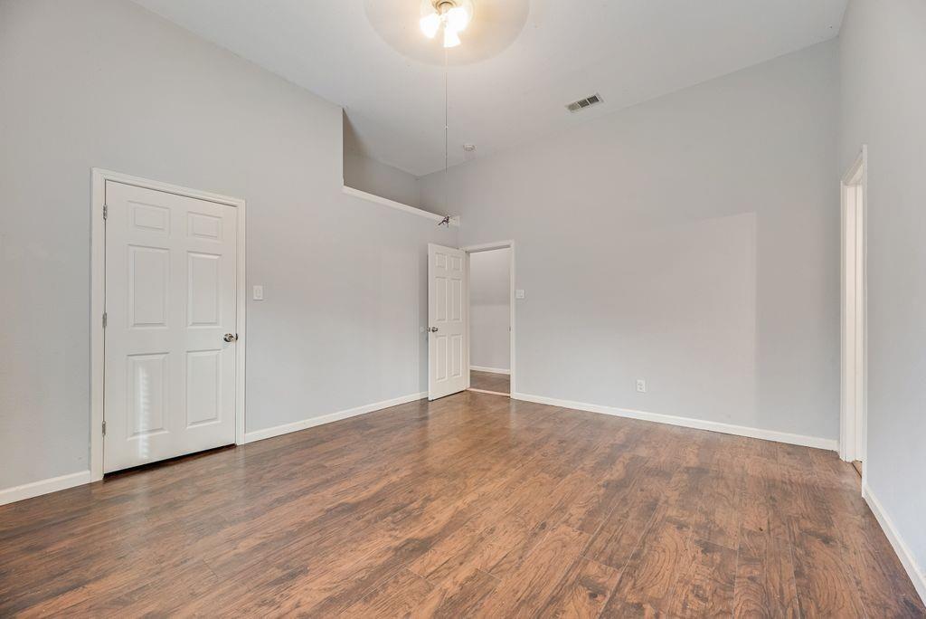500 East Main Street Denison, TX 75021 - Photo 11 of 21 Unfurnished bedroom featuring a high ceiling, dark wood-style flooring, and ceiling fan