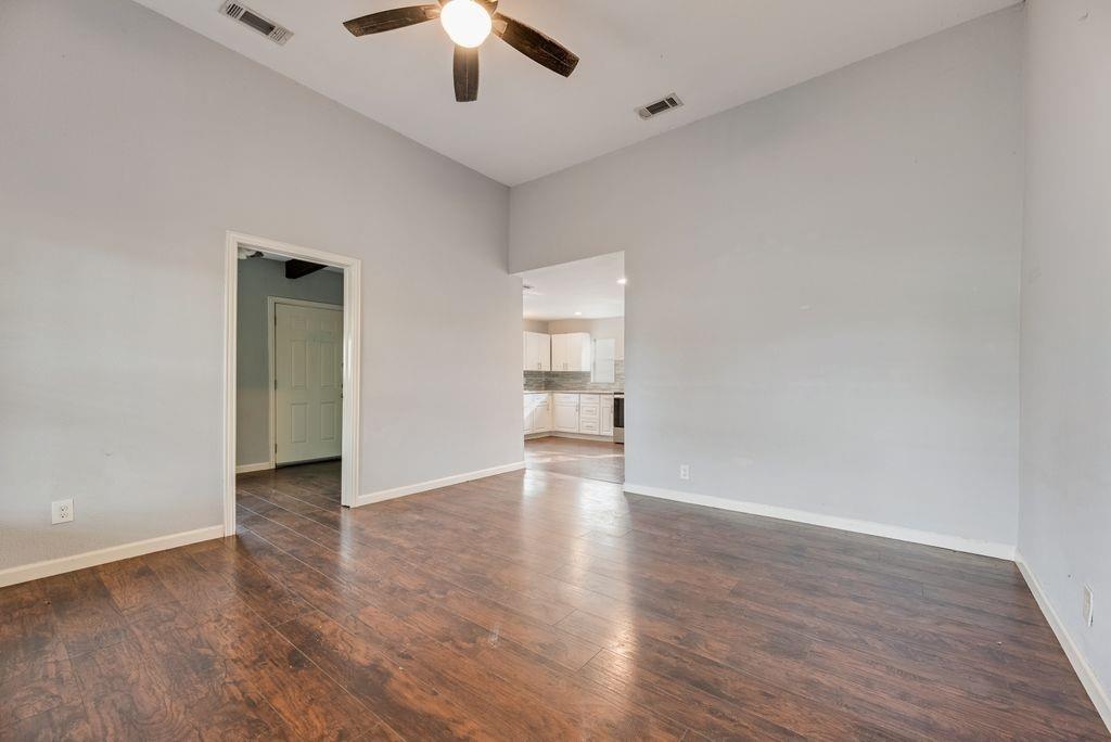 500 East Main Street Denison, TX 75021 - Photo 12 of 21 Empty room featuring ceiling fan and dark wood-style flooring