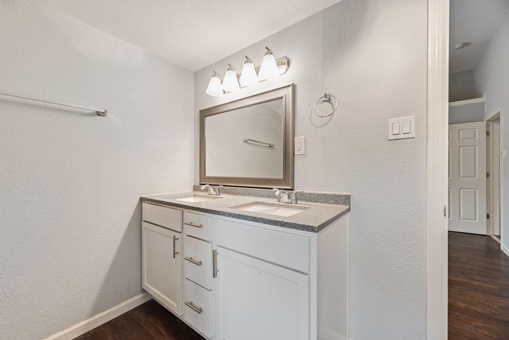 500 East Main Street Denison, TX 75021 - Photo 13 of 21 Full bathroom with a textured wall, double vanity, and dark wood-style floors