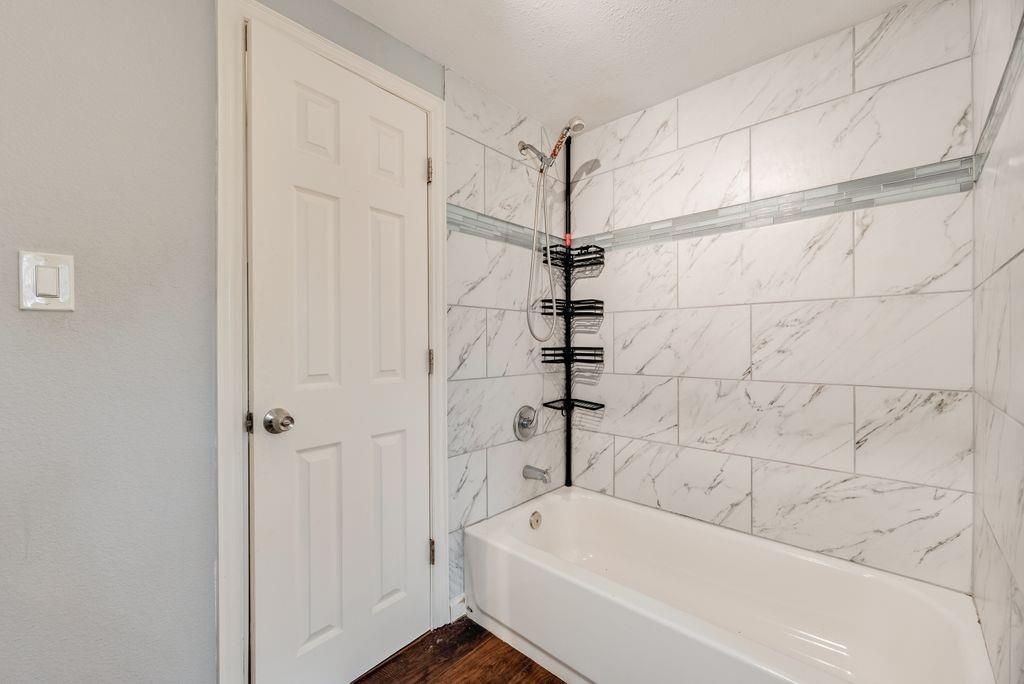 500 East Main Street Denison, TX 75021 - Photo 14 of 21 Bathroom with shower / bathtub combination and dark wood-type flooring