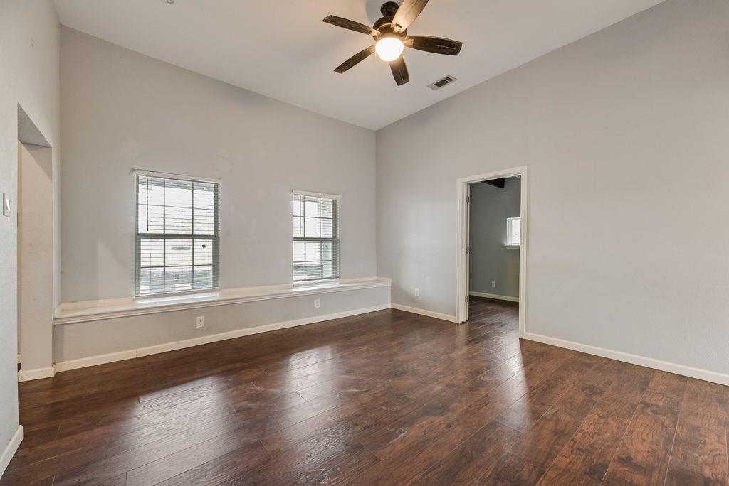 500 East Main Street Denison, TX 75021 - Photo 15 of 21 Spare room with dark wood-type flooring, a ceiling fan, and vaulted ceiling
