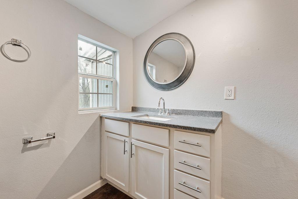 500 East Main Street Denison, TX 75021 - Photo 17 of 21 Bathroom with vanity and a textured wall