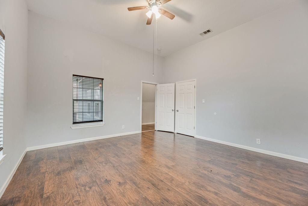 500 East Main Street Denison, TX 75021 - Photo 20 of 21 Unfurnished bedroom with a high ceiling, ceiling fan, and dark wood-style flooring