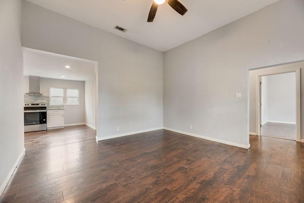 500 East Main Street Denison, TX 75021 - Photo 4 of 21 Unfurnished living room featuring dark wood-type flooring and ceiling fan