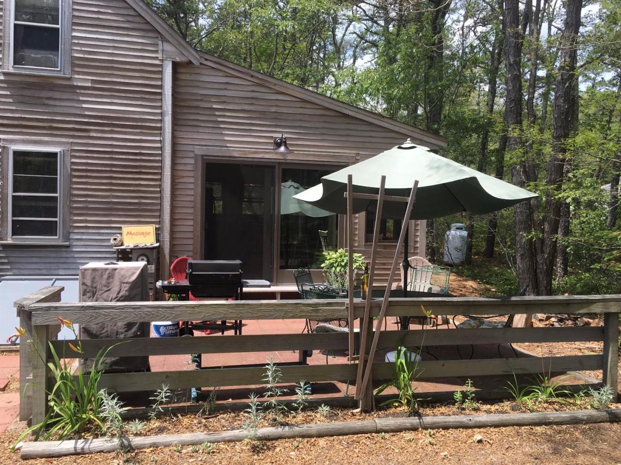150 Gross Hill Road Wellfleet, MA 02667 - Photo 21 of 31 a view of a patio with table and chairs and wooden fence