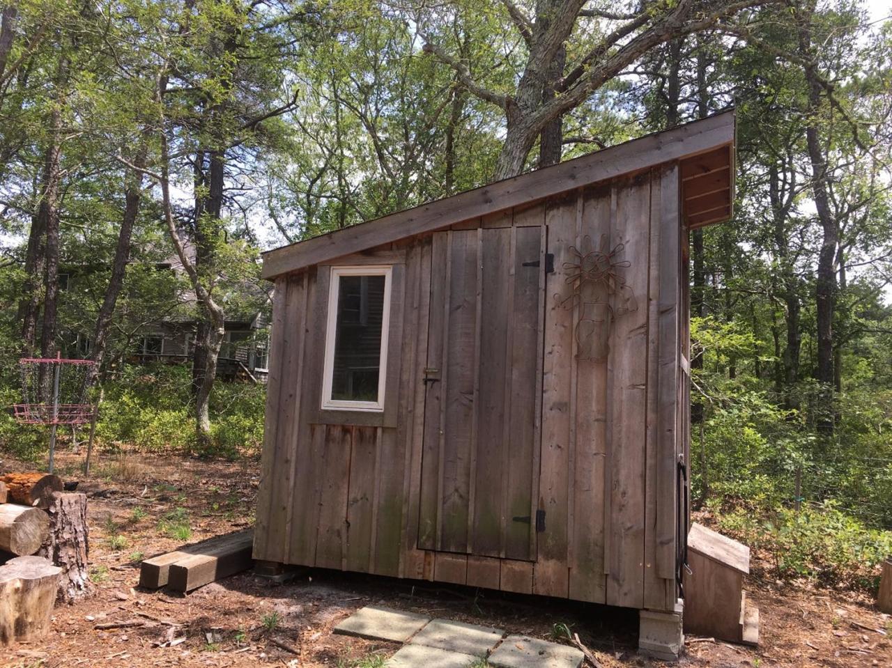 150 Gross Hill Road Wellfleet, MA 02667 - Photo 25 of 31 a view of a house with a wooden door and wooden fence