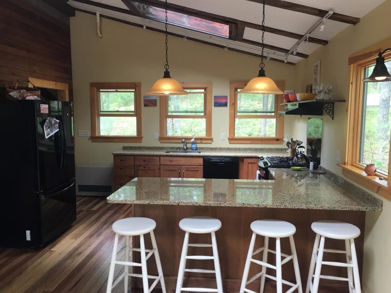 150 Gross Hill Road Wellfleet, MA 02667 - Photo 7 of 31 a kitchen with stainless steel appliances granite countertop a kitchen island hardwood floor sink stove dining table and chairs