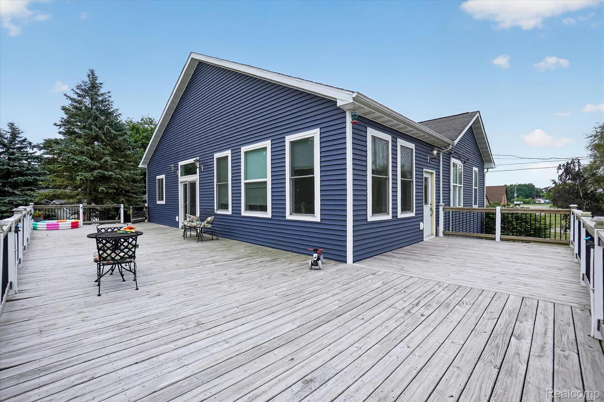 6524 Kelly Road Flushing, MI 48433 - Photo 42 of 47 Expansive wood deck with white railings and black balusters
