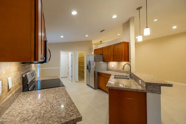 a large kitchen with kitchen island a sink stainless steel appliances and cabinets