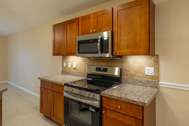 a kitchen with wooden cabinets and a stove top oven