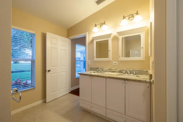 a bathroom with a granite countertop sink and a mirror