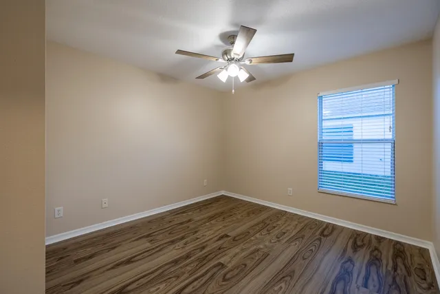 a view of a room with wooden floor and fan