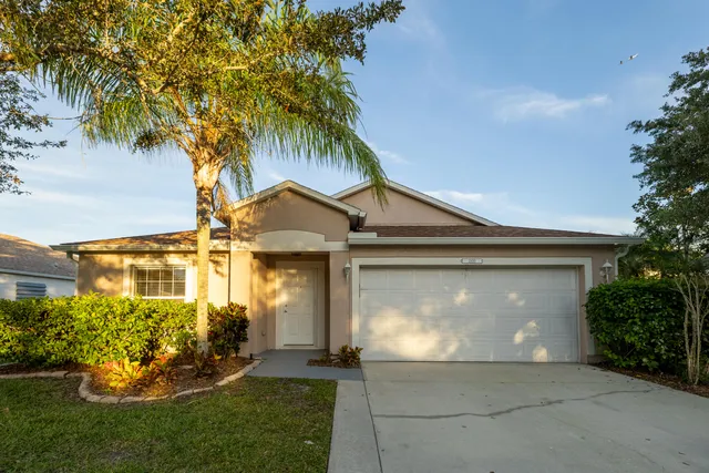 a front view of a house with a yard and a garage