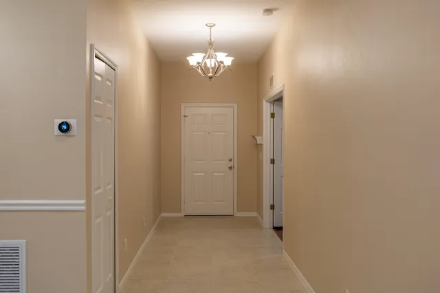 a view of a chandelier in hallway with chandelier