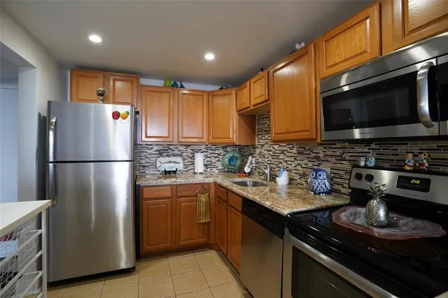 a kitchen with a refrigerator a microwave a sink and cabinets