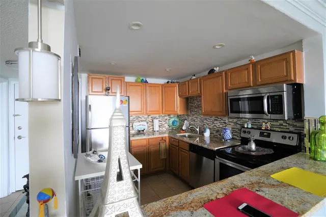 a kitchen with stainless steel appliances kitchen island granite countertop a refrigerator and a stove