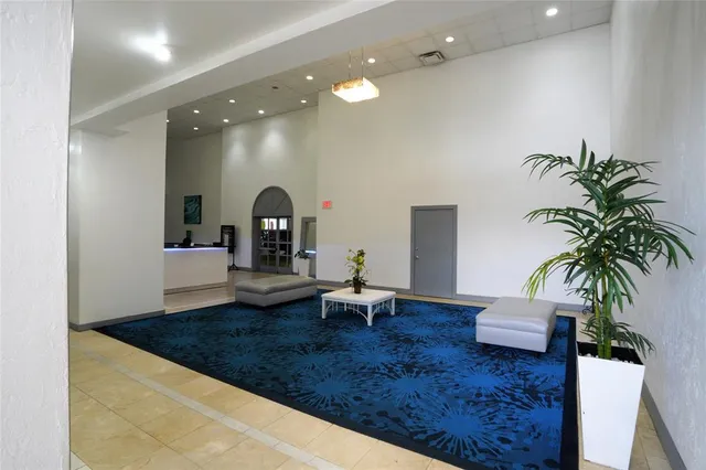 a living room with furniture and potted plants