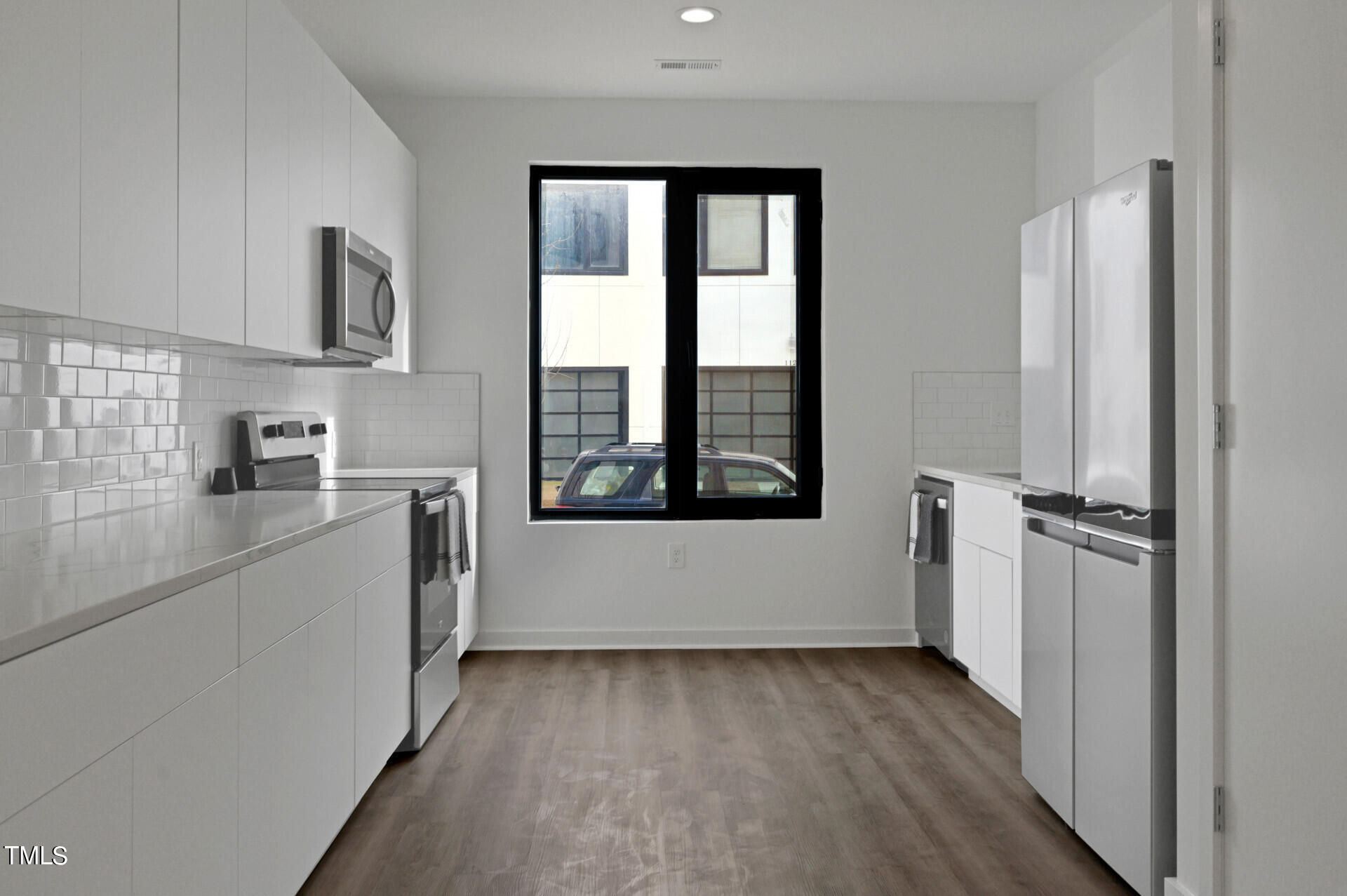 1202 Nova Street Durham, NC 27713 - Photo 7 of 26 a view of a kitchen with a refrigerator stove wooden floor and cabinet
