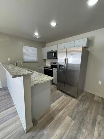 a kitchen with stainless steel appliances granite countertop a refrigerator a stove a sink and a oven