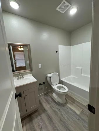 a bathroom with a toilet a sink and mirror