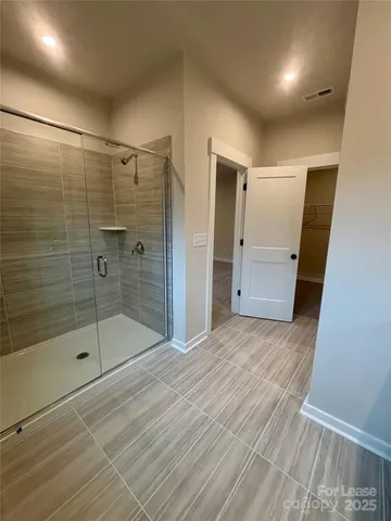 a bathroom with a shower and a glass door