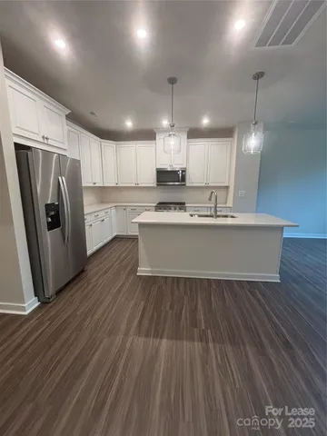a view of kitchen with refrigerator microwave and wooden floor