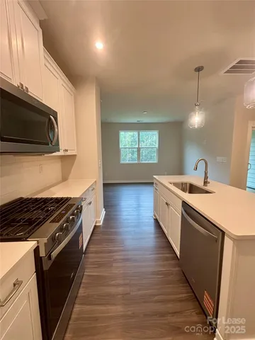 a kitchen with stainless steel appliances kitchen island granite countertop a stove a sink and a microwave