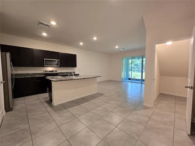 a kitchen with stainless steel appliances a refrigerator and a stove top oven