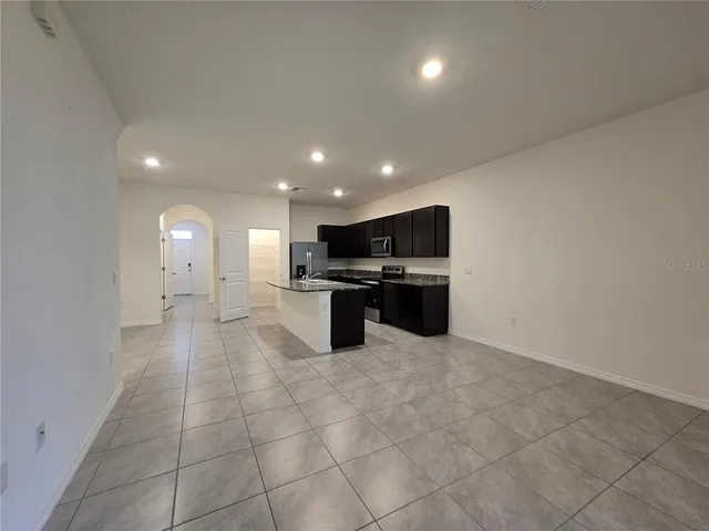 a large kitchen with kitchen island granite countertop a stove and a sink