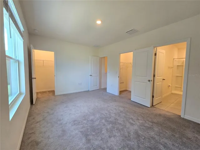 an empty room with windows and closet area