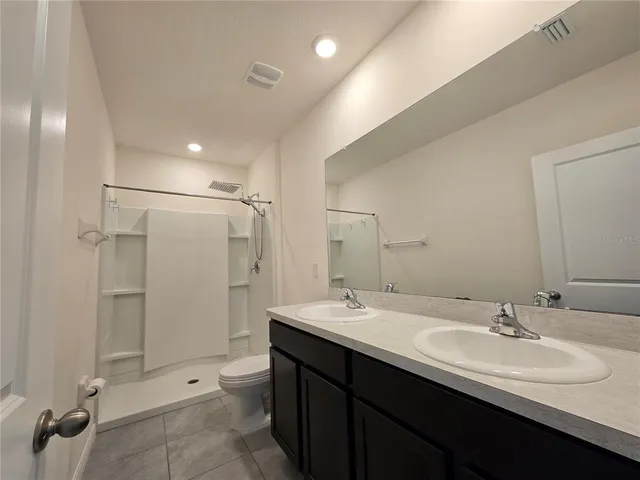 a bathroom with a double vanity sink mirror double and shower