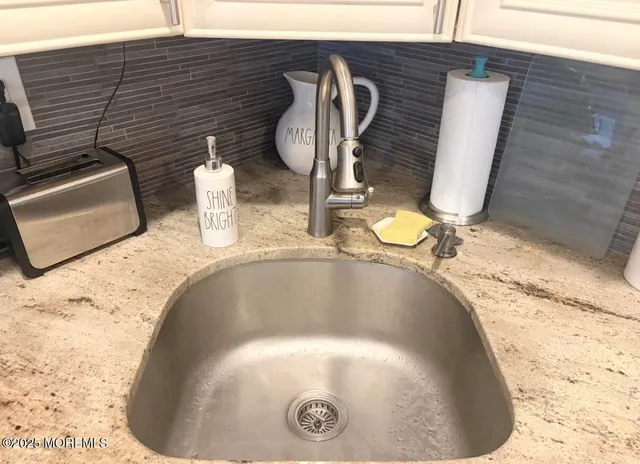 a view of an empty room with kitchen and a window
