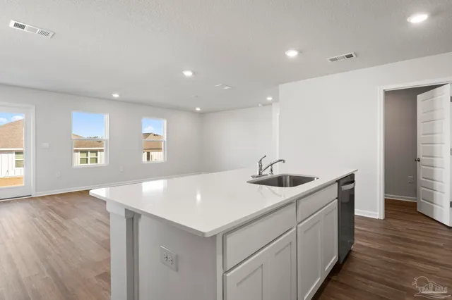 a kitchen with stainless steel appliances granite countertop a sink and dishwasher with wooden floor