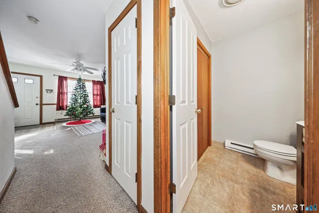 a view of a hallway with wooden floor and a bathroom