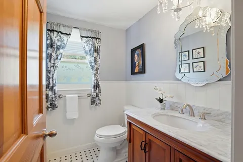 a bathroom with a granite countertop sink mirror vanity and toilet