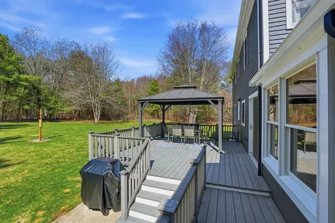 a view of a deck with two chair and a floor to ceiling window