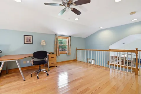 a view of a workspace with furniture and a window