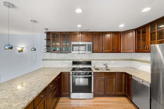 a kitchen with kitchen island granite countertop wooden cabinets and a stove