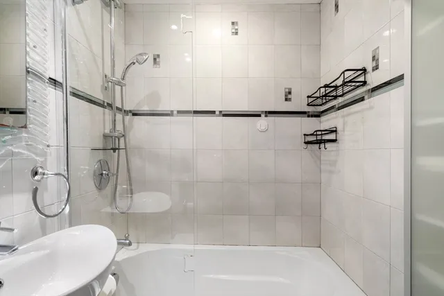 a bathroom with a granite countertop sink a toilet and shower