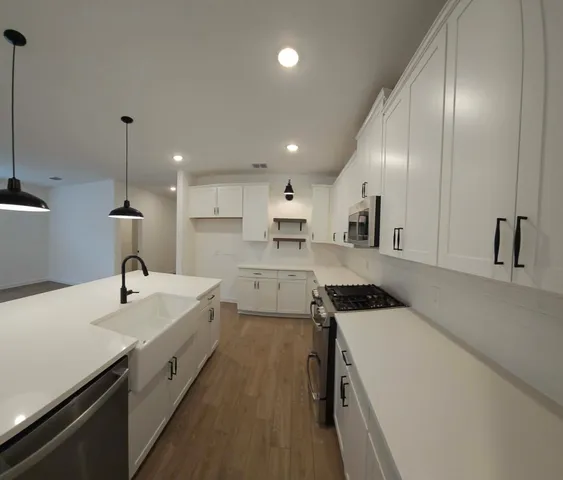 a kitchen with a sink appliances and cabinets