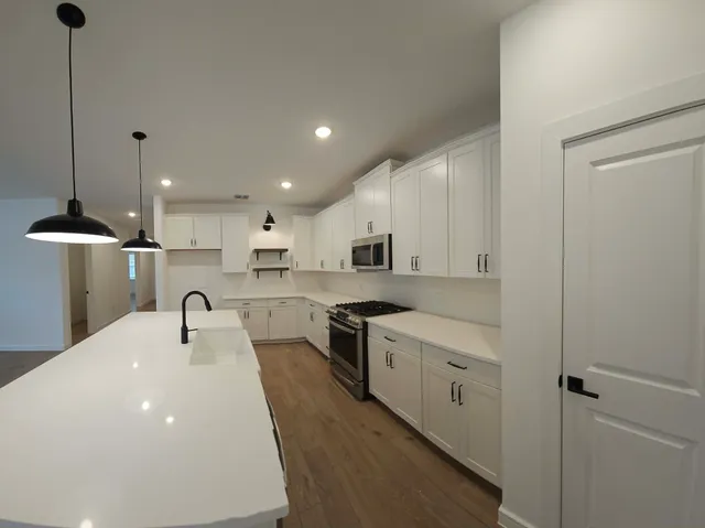 a kitchen with kitchen island a sink stainless steel appliances and cabinets
