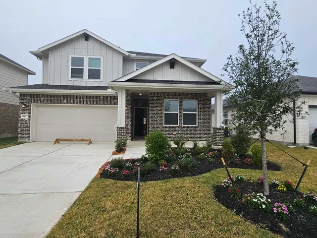 a front view of a house with a yard and potted plants