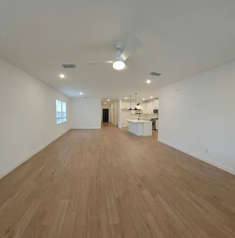 a view of empty room with wooden floor