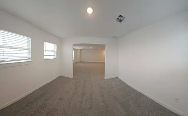 an empty room with windows and closet