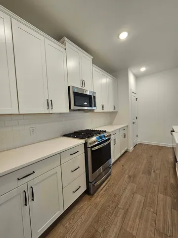a kitchen with granite countertop white cabinets and white appliances