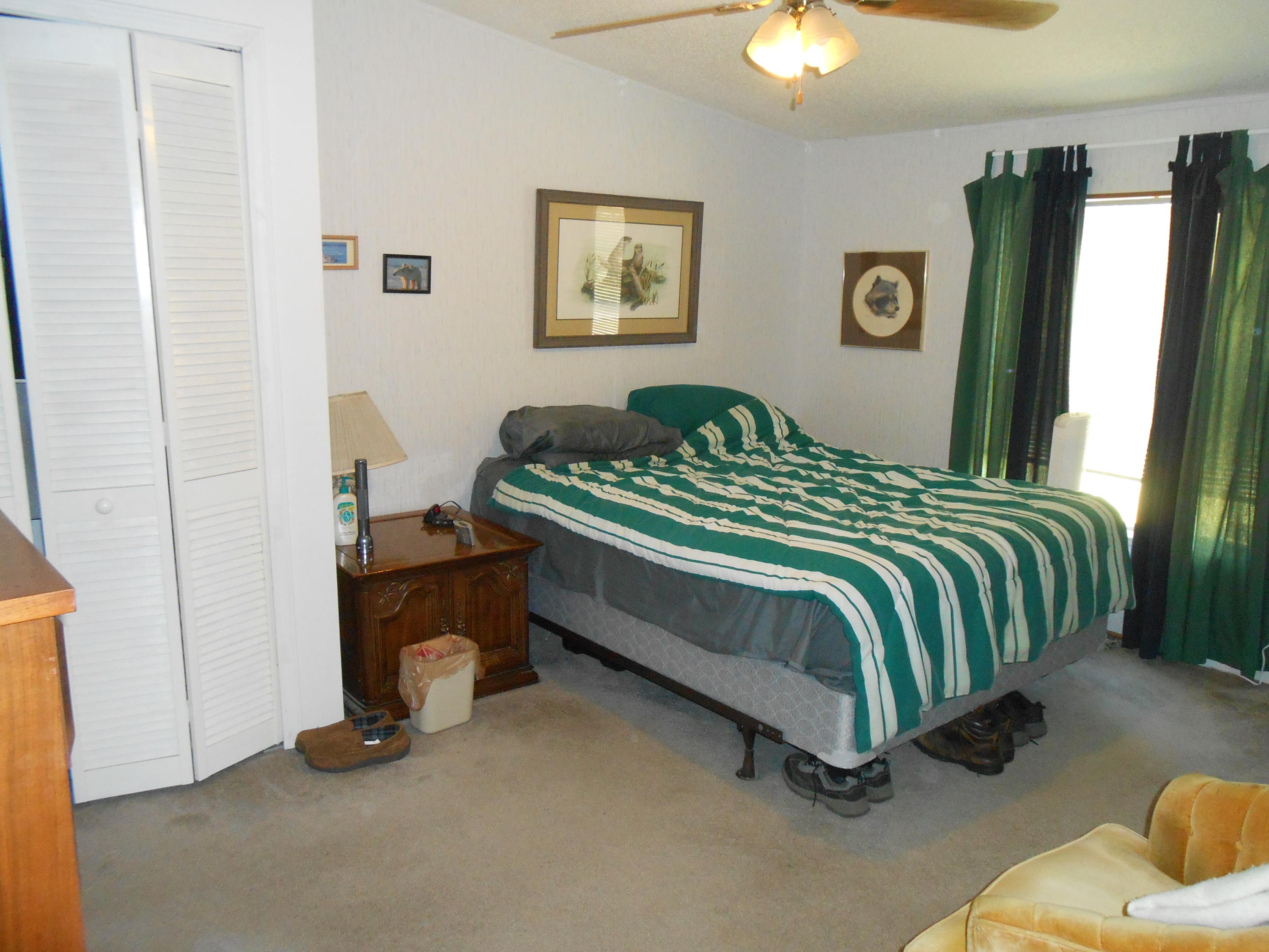 93 West Raphael Road DeFuniak Springs, FL 32433 - Photo 23 of 27 a bedroom with a bed and a chandelier