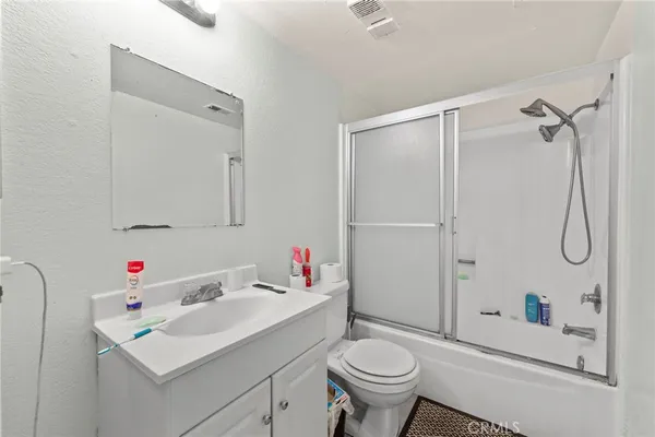 a bathroom with a sink toilet vanity and shower