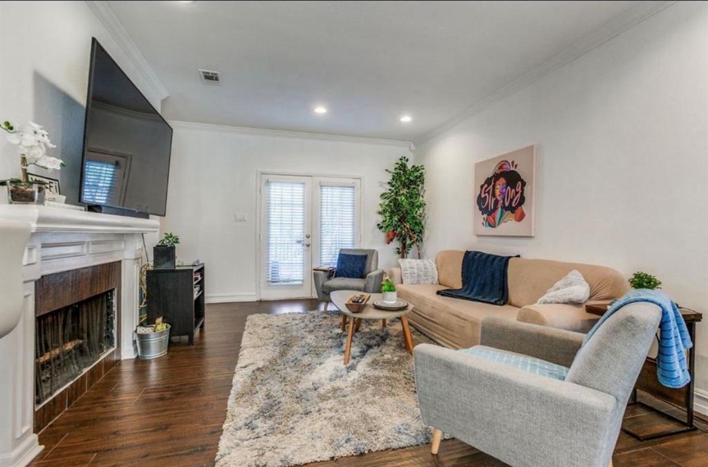 3550 Country Square Drive, Unit 109 Carrollton, TX 75006 - Photo 3 of 13 Living area with dark wood-style floors, ornamental molding, a fireplace, recessed lighting, and french doors